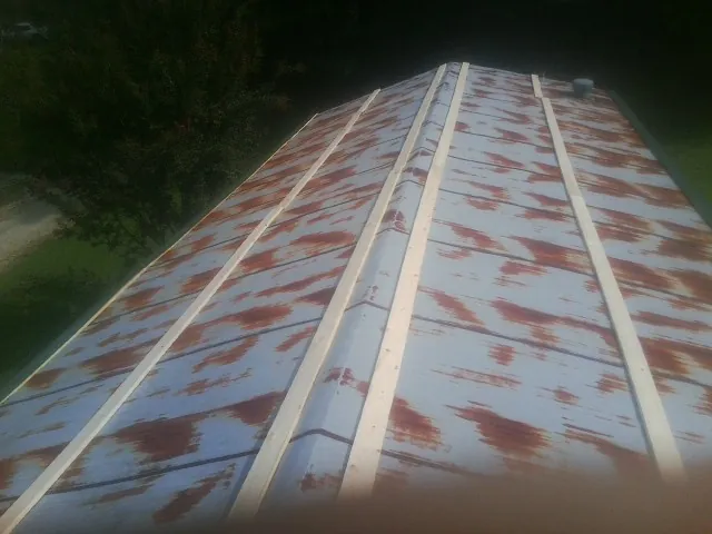 Rusted metal roof panels with new wood purlins before replacement — Storm Damage Roof Repair in Whitfield by Roofing Brothers