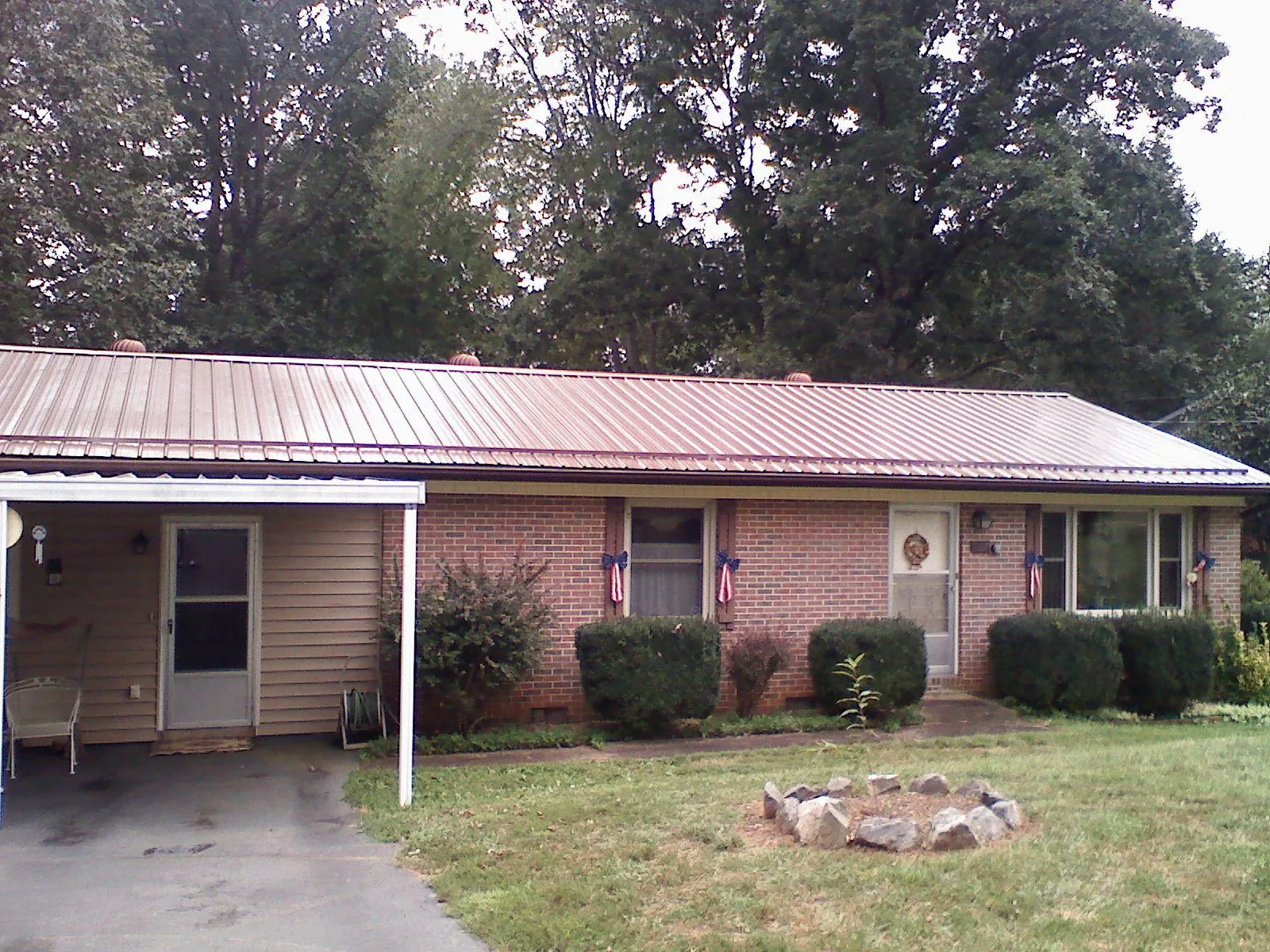 Bronze metal roof and carport on a brick ranch home — Roof Repair work by our crew in Whitfield